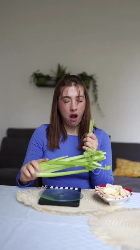 She chooses celery instead of chips Stock Footage 339855118