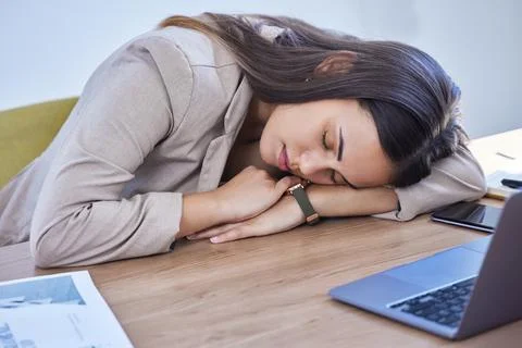 She couldnt focus and dozed off instead. a young businesswoman sleeping at her Stock Photos