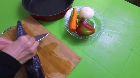 She cuts the fin off the fish, makes an incision. Cutting carrots Stock Footage 79632750
