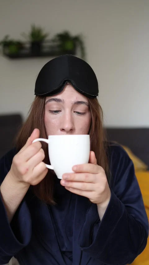 She debates whether to drink her morning coffee Stock-Footage 340087313