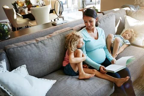She enjoys learning more about the babies development. a pregnant woman spending Stock Photos