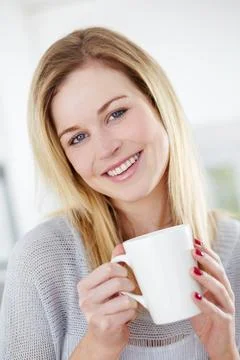 She enjoys a refreshing cup of tea. Cute young woman drinking a cup of coffee Stock Photos