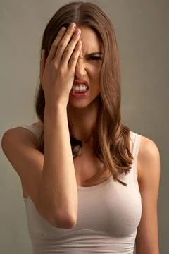 She has a dangerous side. Studio portrait of an expressive young woman covering Stock Photos