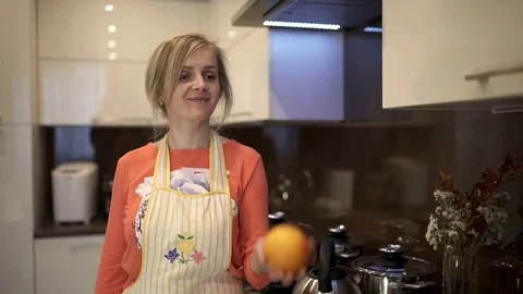 She juggles a large grapefruit. She is happy and smiling into the camera. Slow Stock Footage 74348787
