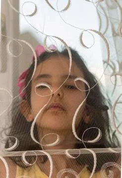 She looking at the camera behind the curtain Stock Photos