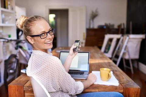 She makes multitasking look easy. A portrait of a beautiful young woman working Stock Photos