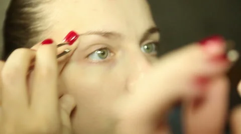 She plucks her eyebrows look in the mirror Video stock 58324514