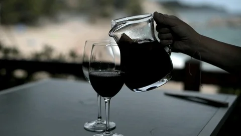 She pours the Sangria into two glasses Stock Footage 88902142