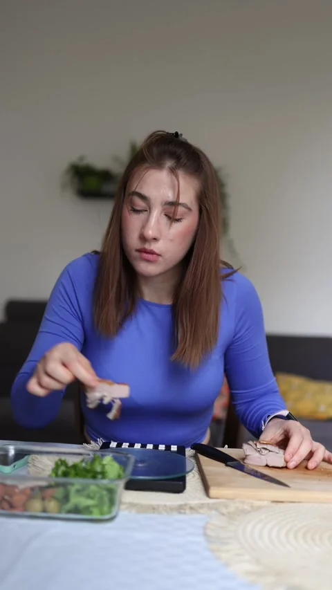 She repeatedly weighs the same piece of chicken Stock Footage 339855358
