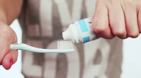 She squeezes the toothpaste on the toothbrush. Stock Footage 59311198