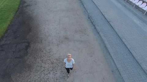 She is in the stadium, a top view. Flying over the running girl Video stock 71280436