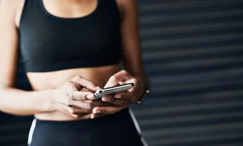 She tracks her progress on her cellphone. Closeup shot of a sporty woman using a Foto stock
