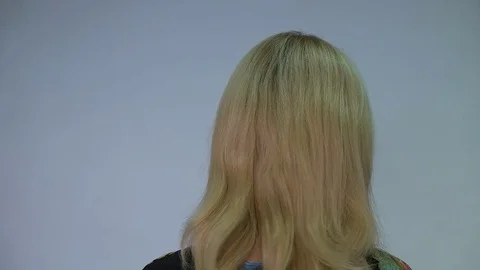 She turns to the camera and adjusts hair Stock Footage 70233634