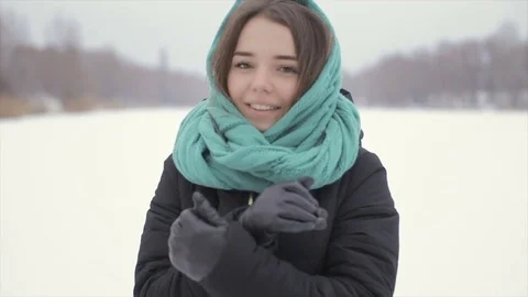 She warms his hands at winter standing in the snow. Full hd video Stock Footage 72330513
