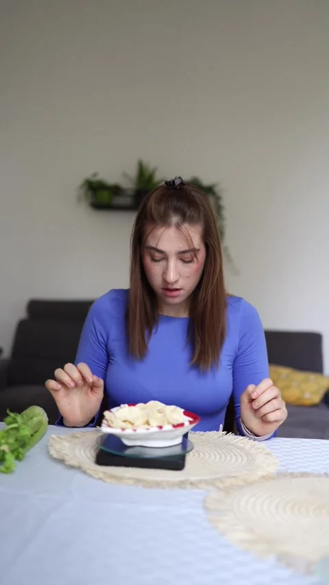 She weighs chips before allowing herself to eat Stock Footage 339855135