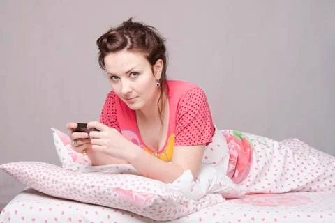 She wrote a sms, lying in bed Stock Photos