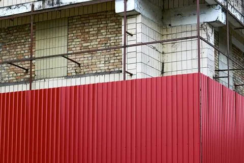 Sheathing of a building construction being repaired a metal red sheet profile Stock Photos
