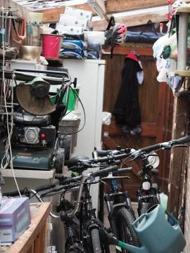 A shed with a jumble of things inside, including three bicycles Foto stock