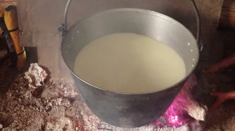Sheep milk cooked in an iron pot over a fire right in the wooden house Stock Footage 43224948