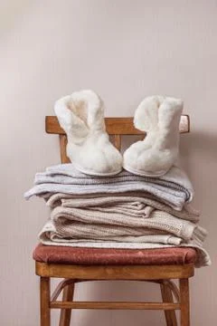 Sheepskin slippers, stack of warm clothes Stock Photos