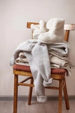 Sheepskin slippers, stack of warm clothes Stock Photos