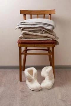 Sheepskin slippers, stack of warm clothes Stock Photos