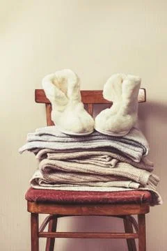 Sheepskin slippers, stack of warm clothes Stock Photos