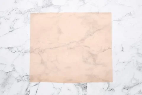 Sheet of baking paper on white marble table, top view Stock Photos