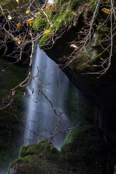 Sheet of falling water between rocks in a mountain landscape Stock Photos