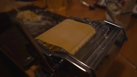 Sheet of Fresh Pasta is Passed Through Hand-Cranked Pasta Cutter Stock Footage 97277306