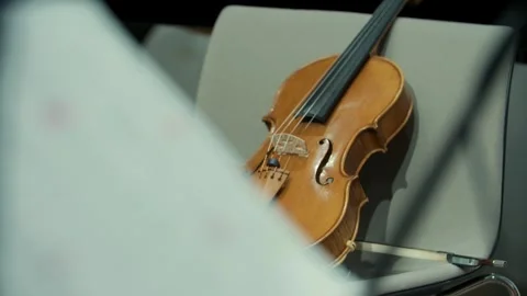 Sheet with notes and a violin in the background, focus shift, music, 4k Stock Footage 342938420