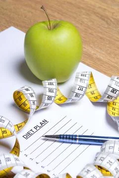 Sheet of paper with diet plan, apple, pen and measure tape Stock Photos