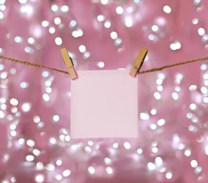 Sheet of paper for notes on hanging clothespins with bokeh in the background Stock Photos
