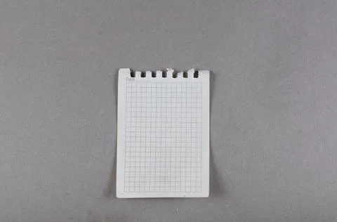 Sheet of paper torn from spring-loaded notebook on gray background. Top view. Stock Photos