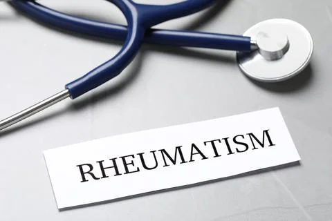 Sheet of paper with word Rheumatism and stethoscope on table, closeup Stock Photos