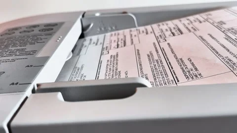 Sheets are placed in the upper tray of the copier for processing. Stock Footage 317453452