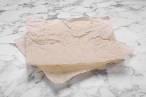 Sheets of baking paper on white marble table Stock Photos