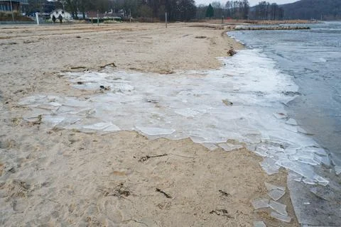 Sheets of broken ice piled up on the sandy beach at Wassersleben near Flens.. Stock Photos