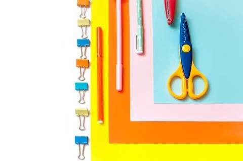 Sheets of colored paper, scissors and supplies on a white table. Stockfoto's
