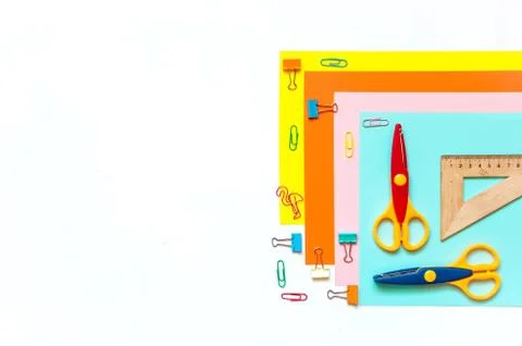 Sheets of colored paper, scissors and supplies on a white table. 写真素材