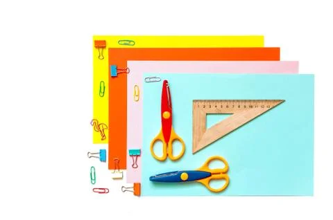 Sheets of colored paper, scissors and supplies on a white table. Fotos Stock
