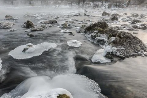 Sheets of ice floes in flowing river Isar near Munich on cold foggy winter da Stock Photos