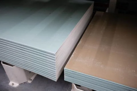 Sheets of moisture-resistant drywall of different brands are stacked in bundles Foto stock