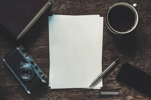 Sheets of paper, retro camera and smartphone on table. Writing a story. Stock Photos