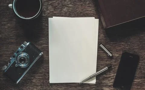Sheets of paper, retro camera and smartphone on table. Writing a letter Stock Photos