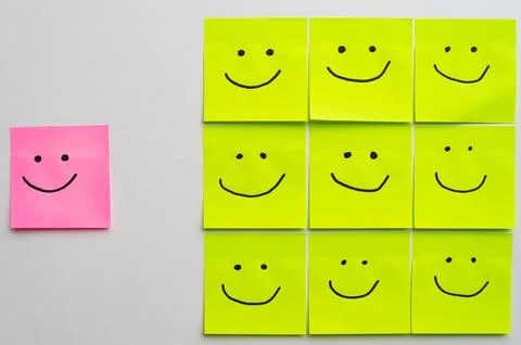 Sheets of paper with smiley faces drawn on them. Stock Photos