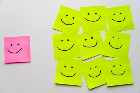 Sheets of paper with smiley faces drawn on them. Stock Photos