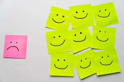 Sheets of paper with smiley faces drawn on them. Stock Photos