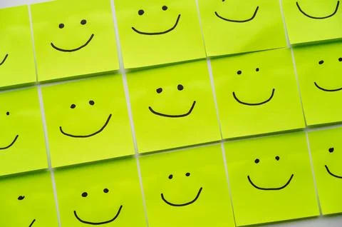 Sheets of paper with smiley faces drawn on them. Stock Photos