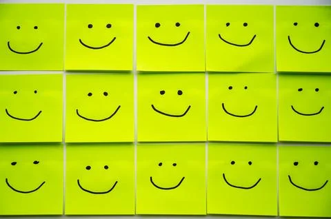 Sheets of paper with smiley faces drawn on them. Stock Photos